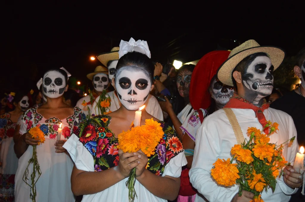 A Day of the Dead procession with candles and painted faces