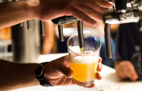 This image shows a man filling a glass with beer.