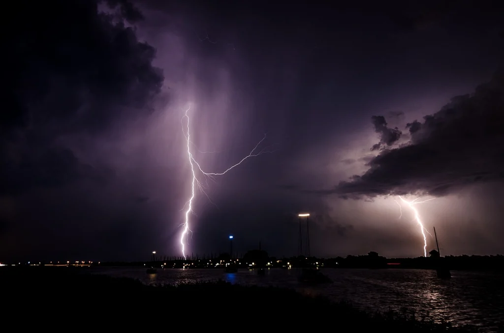 Lightning hits near a city at night.