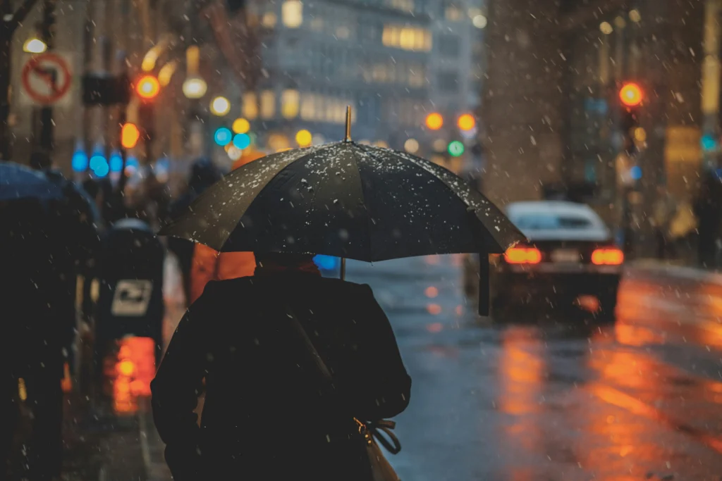 A man standing under an umbrella in the rain