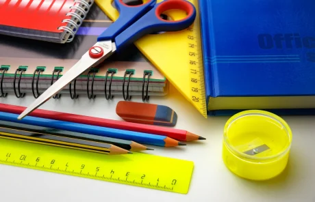 This image shows different classroom items like scissors, a ruler, different pencils, a sharpener, and notebooks.