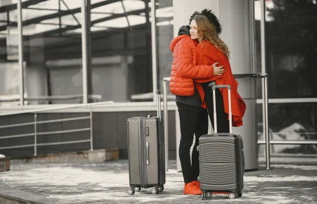 A man and a woman hugging each other at a train station.