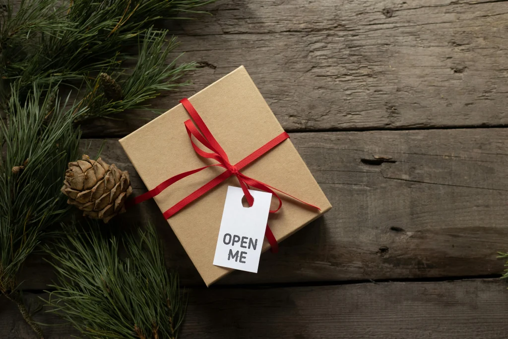 This image shows a gift box tied with ribbon and a tag that reads “Open Me.”